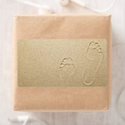 Voetafdrukken op zandstrand achtergrond etiket (Insitu)