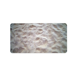 Voetafdrukken op zandtextuur etiket