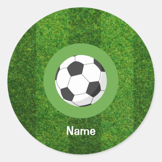 Voetbal met bal op groen gras ronde sticker (Voorkant)