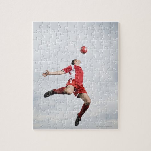 Voetbalspeler en voetbal in de lucht legpuzzel (Verticaal)