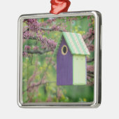 Vogelhuis op een roodbaars metalen ornament (Links)