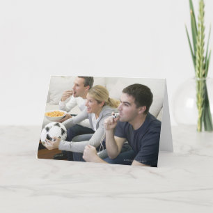 Vrienden die op TV met fluitje, football letten en Kaart