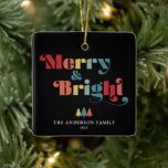 Vrolijk en kleurrijk kerstfeest keramisch ornament<br><div class="desc">Dit vierkante kerstboom ornament heeft de tekst "Merry & Bright" in een levendige,  retro stijl. De tekst valt op tegen een zwarte achtergrond,  waardoor een visueel opvallend contrast ontstaat. Personaliseer dit retro thema ornament met jouw naam en jaar. Fotografie © Storytree Studios,  Stanford,  CA</div>