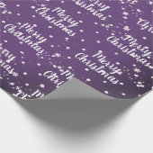 Vrolijk kerstbericht in sneeuwvlokken op rode vlok cadeaupapier (Hoek)