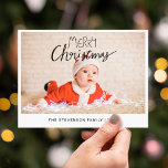 Vrolijk kerstfeest moderne eenvoudige foto feestdagenkaart<br><div class="desc">Stuur dit eenvoudige en moderne kerstcadeautje naar je familie en vrienden. Deze kerstkaart is personaliseerbaar door één van uw favoriete foto's, uw familienaam, en jaar toe te voegen, en kenmerkt een trendy bekledingstekst die "Vrolijk Kerstmis"in moderne handgeschreven doopvonten leest. De achterzijde van de kaart is aanpasbaar met uw retouradres, uw...</div>