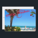 Vrolijk kerstfeest vanuit Vero Beach Florida Ocean Feestdagenkaart<br><div class="desc">Vrolijk kerstfeest uit Vero Beach, Florida! Dit kleurrijke, tropisch-gethemde platte wenskaart is voorzien van een foto-afbeelding van een prachtig gebied rond de Vero Beach oceanfront dat allemaal gedecodeerd is voor de feestdagen. Het feestelijke ontwerp omvat kerstlichten op het groen, kerstballen die aan een palmschijfje hangen, en de tekst "Vrolijk kerstfeest"...</div>
