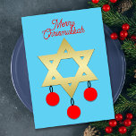 Vrolijke Christusmukkah Davidster en Ornamenten Feestdagenkaart<br><div class="desc">Deze Merry Chrismukkah-kaart heeft een gouden Davidster in het midden op een blauwe achtergrond. Er hangen drie rode kerstversieringen aan de Davidster. Bovenaan de kaart staan de woorden "Merry Chrismukkah" in rood schrift. Op de achterkant van de platte kaart staat het ontwerp op kleinere schaal met de vakantiebegroeting eronder. U...</div>