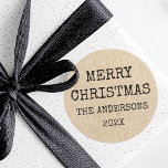Vrolijke kerstnaam typemachine Kraft look Ronde Sticker<br><div class="desc">Kerstvakantie stickers met de tekst "Merry Christmas" en uw familienaam en het jaar hieronder in een lettertype typemachine stijl op een afgedrukte afbeelding Kraft papier look achtergrond.</div>