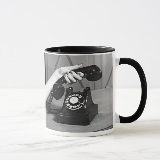 Vrouw die de telefoon oppakt, dicht bij de hand mok (Rechts)