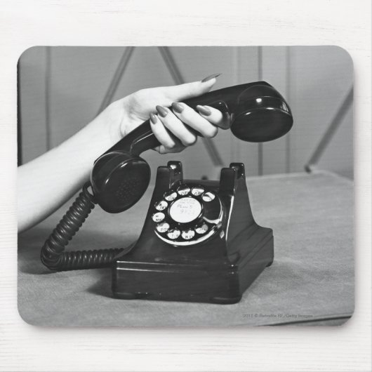 Vrouw die de telefoon oppakt, dicht bij de hand muismat (Voorkant)