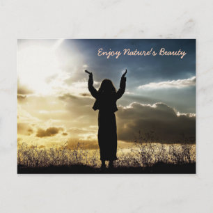 Vrouw die geniet van zonsonderend Briefkaart