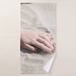 Vrouw die op wit zand ligt badhanddoek
