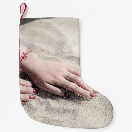 Vrouw die op wit zand ligt kleine kerstsok (Voorkant)
