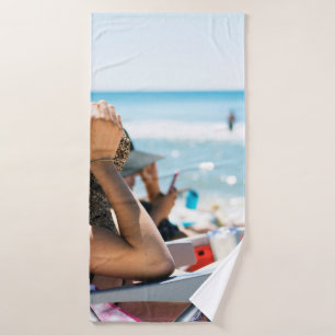 Vrouw die op zonlounger ligt en haar gezicht bedek badhanddoek