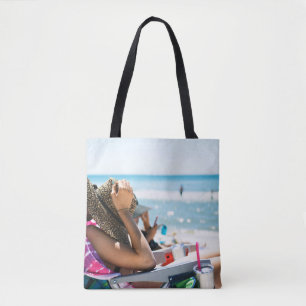Vrouw die op zonlounger ligt en haar gezicht bedek tote bag