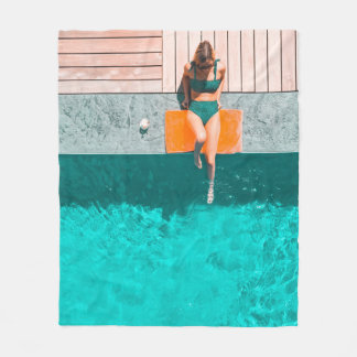 Vrouw die 's ochtends naast het zwembad ligt fleece deken