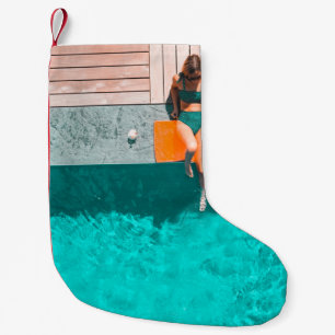 Vrouw die 's ochtends naast het zwembad ligt kleine kerstsok