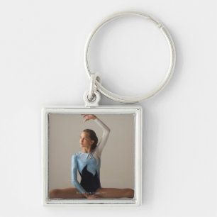 Vrouw gymnast (12-13) die spleten vertoont sleutelhanger