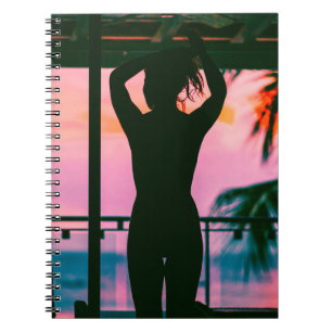 Vrouw in zwarte tankwagen en broek aan de rand notitieboek