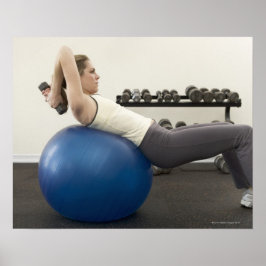 Vrouw met een trainingsbal en een handgewicht poster