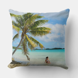 Vrouw onder een palmboom gooit kussen