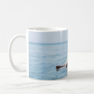 Vrouw op een opblaasbare drijver in de oceaan geri koffiemok