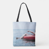 Vrouw op een opblaasbare drijver in de oceaan geri tote bag (Achterkant)
