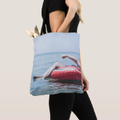 Vrouw op een opblaasbare drijver in de oceaan geri tote bag (Dichtbij)