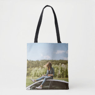 Vrouw op het dak van een witte sedan tote bag