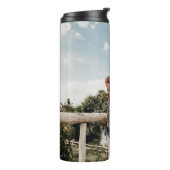 Vrouw op terras thermosbeker (Gedraaid links)