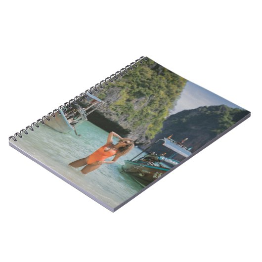 Vrouw op waterlichaam tussen bruine boten notitieboek (Linkerzijde)