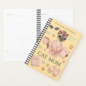 Vrouwelijke kat houdt dagelijkse planner vast (Display)