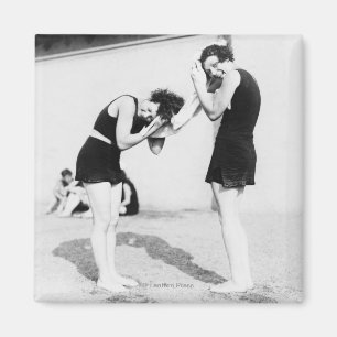 Vrouwen die hun haar drogen in het strand magneet