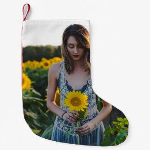 Vrouwen die op zonnebloemveld staan kleine kerstsok