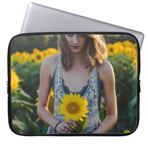 Vrouwen die op zonnebloemveld staan laptop sleeve