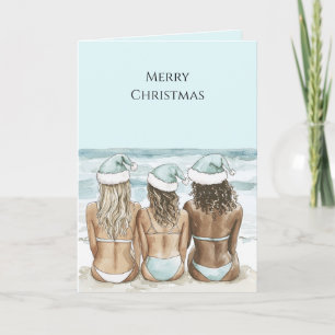 Vrouwen in kerstmannenhoeden op het strand met Ker Kaart