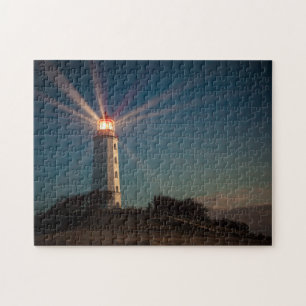 Vuurtoren op een heuveltje bij nacht legpuzzel