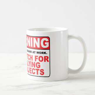 WAARSCHUWING Let op vliegende objecten! Koffiemok