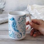 Waterverf van de kustblauwe zeepaardjes en de kora koffiemok<br><div class="desc">Voeg een kuststijl toe aan je huis met mijn  latte mok,  ontworpen met mijn oorspronkelijke hand geschilderd zeepaard met koraal. Waterverf Kunstwerk van Victoria Rigali-Design. Perfect strandthema kerstcadeau onder $25. Om meer design te zien,  bezoek VG nodigt in www.zazzle.com/dotellabelle uit</div>