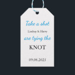 We zijn de knoop wit en blauw aan het binden cadeaulabel<br><div class="desc">Vier je grote dag met een vleugje plezier! Dit moderne witte bruiloftsgunst label met blauw en zwart script bevat de speelse boodschap: "Neem een schot, we binden de knoop!" Perfect voor het bevestigen aan mini-drankflessen, gunstzakken of welkomstdozen. Voeg je namen en trouwdatum toe om het een gepersonaliseerde herinnering te maken...</div>
