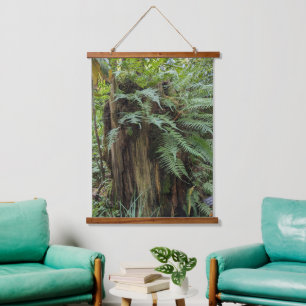 Weelderige varens die op een boomstronk groeien hangend wandkleed