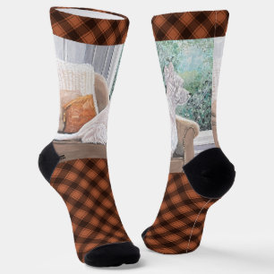 Westie kijkt uit een raam sokken