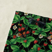 Wilde aardbeien op zwart strandlaken (In situ)