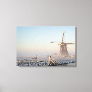 Windmolen in de sneeuw tegen zonnestaafdruk canvas afdruk