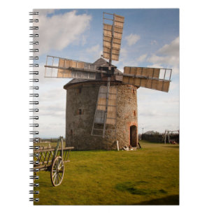 Windmolen in groen veld en witte wolken en blauwe  notitieboek