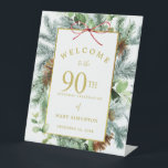 Winter Botanische 90th Birthday Party Welcome Reclamebord Met Voetstuk<br><div class="desc">Elegant winter botanische griep verwelkomde bord voor een 90e verjaardag op de verjaardag van de geboorte in december, januari of februari. Donkere groene dennennetjes met lichtgroene eucalyptusbladeren en wijnstokken. Bruine dennenkegels voegen textuur en diepte toe. Een rechthoekig gouden lijst geeft het een elegante rustige vibe. De 80ste verjaardag van de...</div>