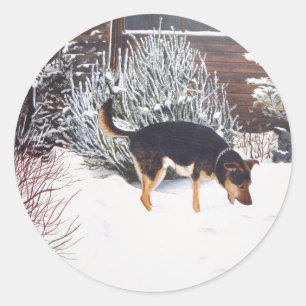 Wintersneeuwscène met schattige zwarte en geelbrui ronde sticker
