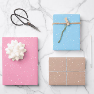 Wintersneeuwvlokken op roze, blauw en bruin inpakpapier vel