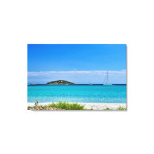 Wit zandstrand turquoise water rotsen & zeilboot