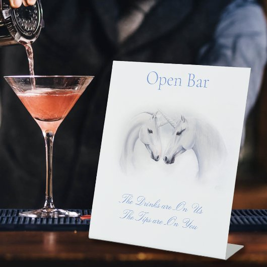 Witte eenhoorns houden van paar open bar reclamebord met voetstuk